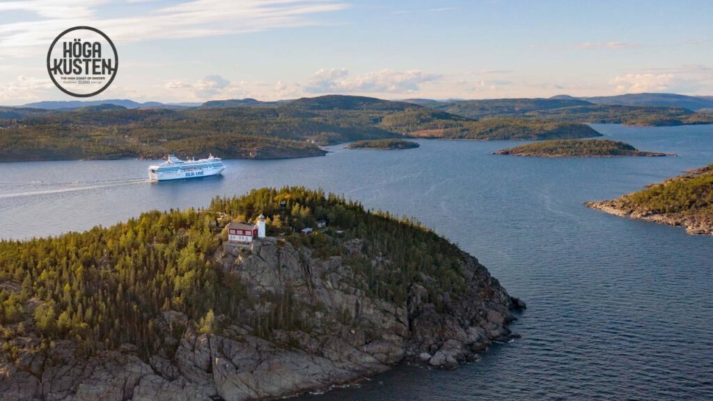 Översiktsvy över Högbonden med en färja som passerar på havet.